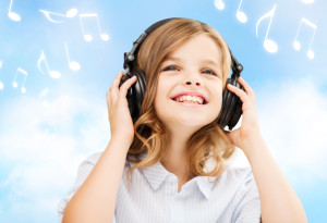 home, leisure, new technology and music concept - smiling little girl with headphones over blue sky background and music notes